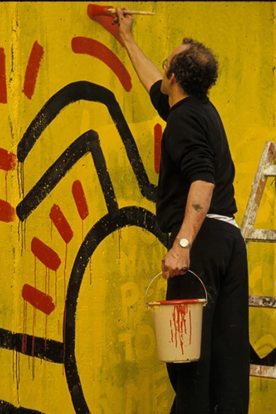 Keith Haring malt an die Berliner Mauer