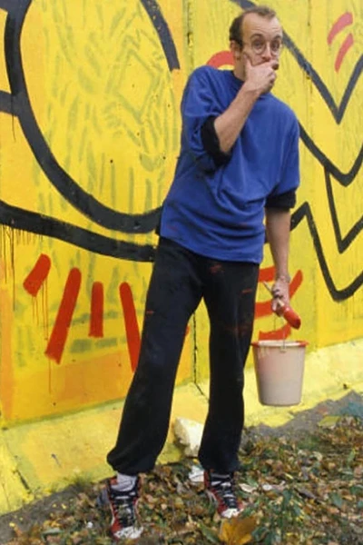 Keith Haring posed an der Berliner Mauer