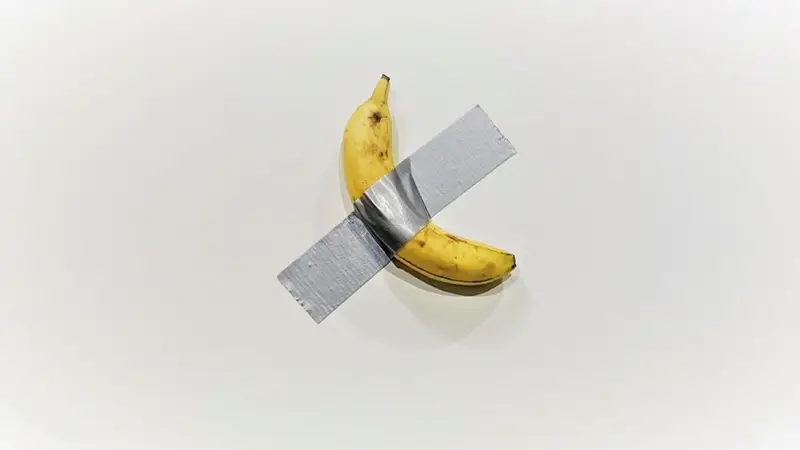 Banane mit grauem Klebeband an einer weißen Wand
